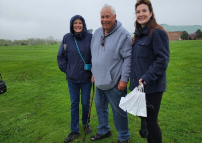 a man and two women stand outside smiling
