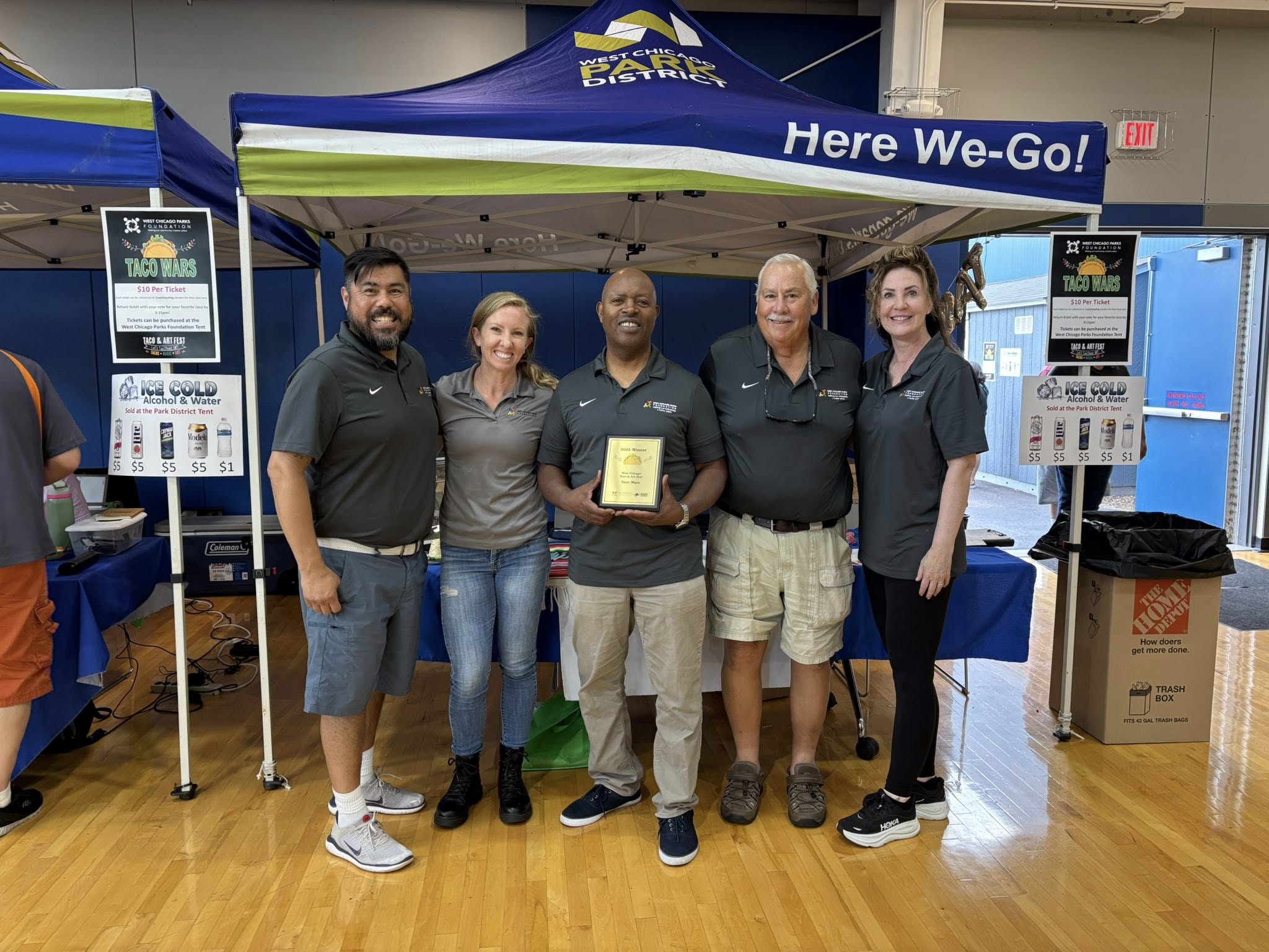 tw1 Five members of the west chicago parks foundation pose for a photo holding a plaque to be given to the winners of the 2025 taco wars
