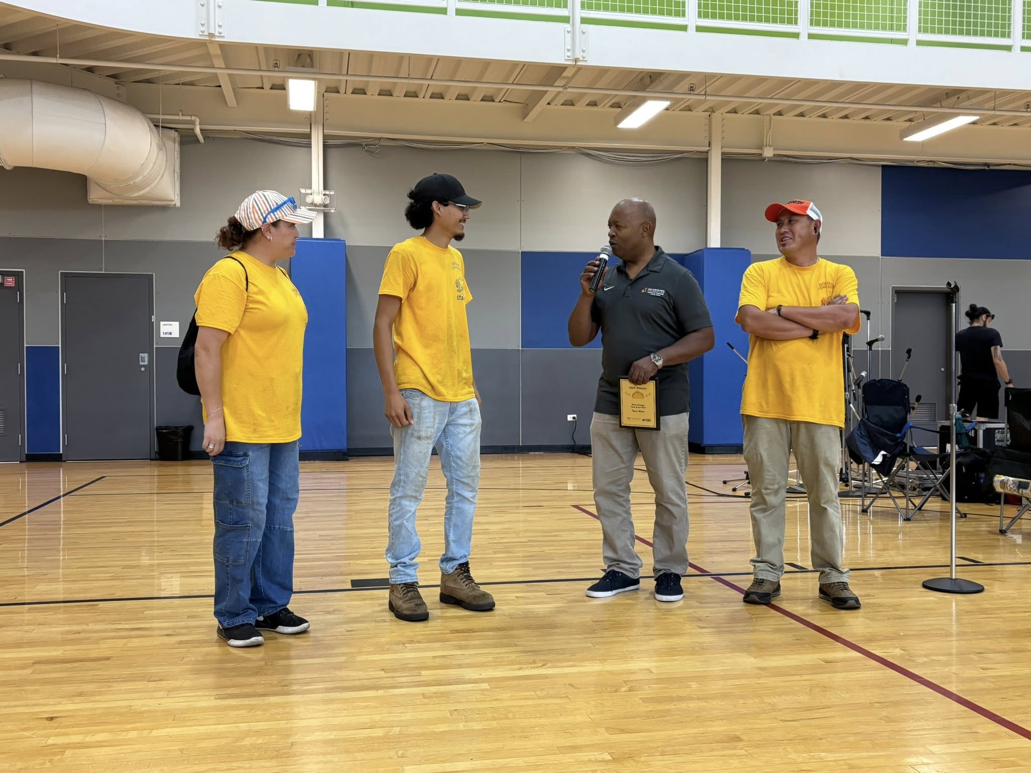 tw4 Three workers from the shop 'La India' standing as the president of the west chicago parks foundation speaks in a microphone