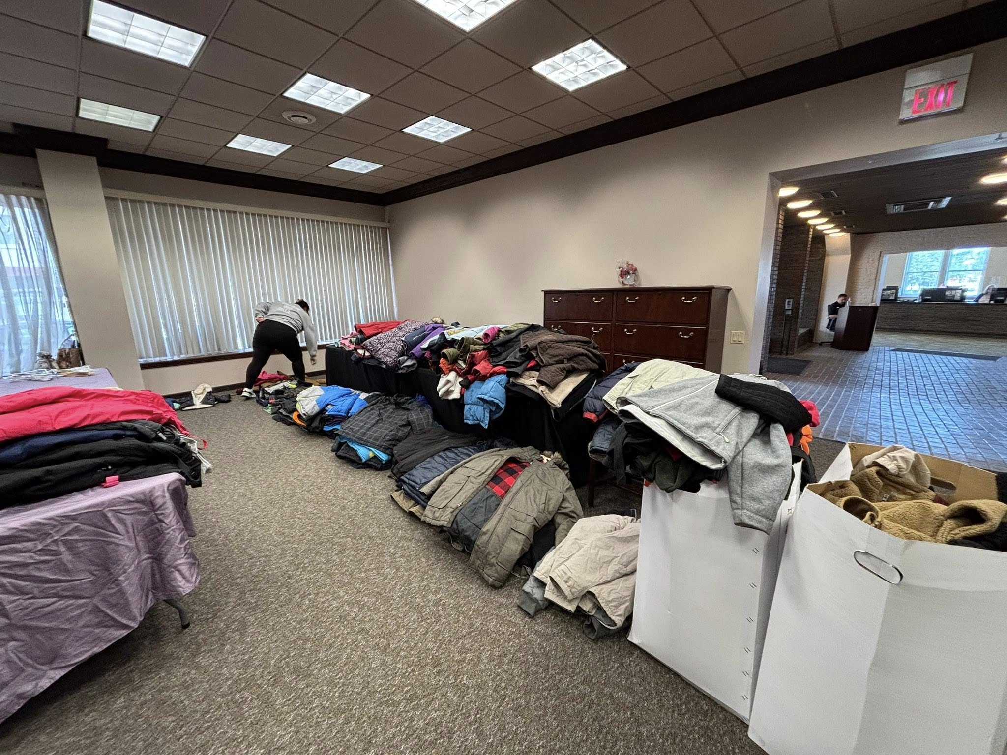 wego donation 2 Hundreds of coats sorted into piles on tables and the floor